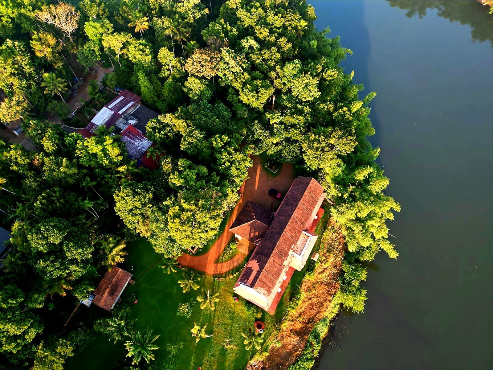 Aerial view of De Charlie's Pamba Heritage at golden hour, on the banks of the Pamba